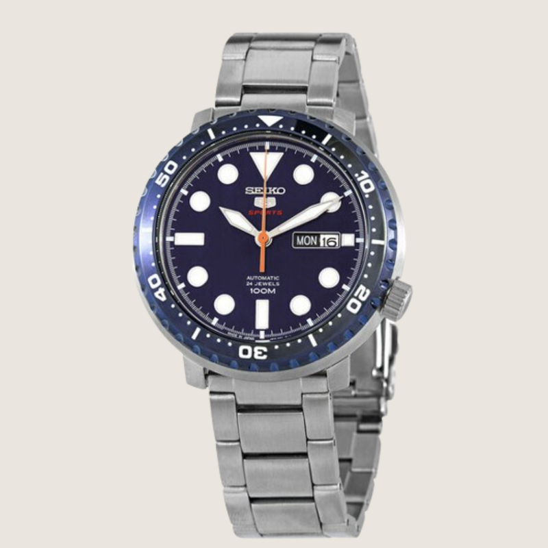 Seiko 5 Sports Bottle Cap SRPC63J1, navy dial and blue bezel, on a plain bone background