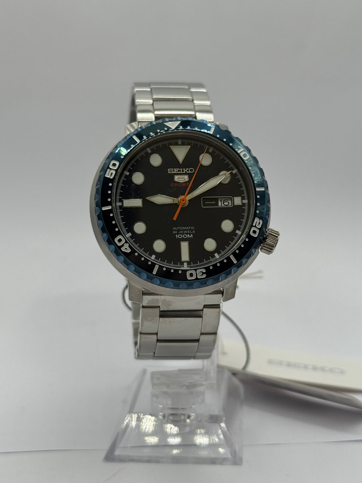 Seiko 5 Sports Bottle Cap SRPC63J1 on stand, navy dial and steel bracelet