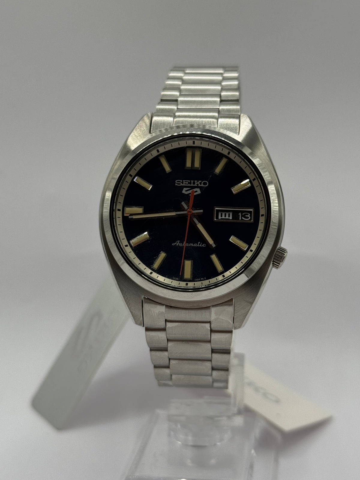 Seiko 5 Sports SNXS SRPK87K1 on stand with steel bracelet